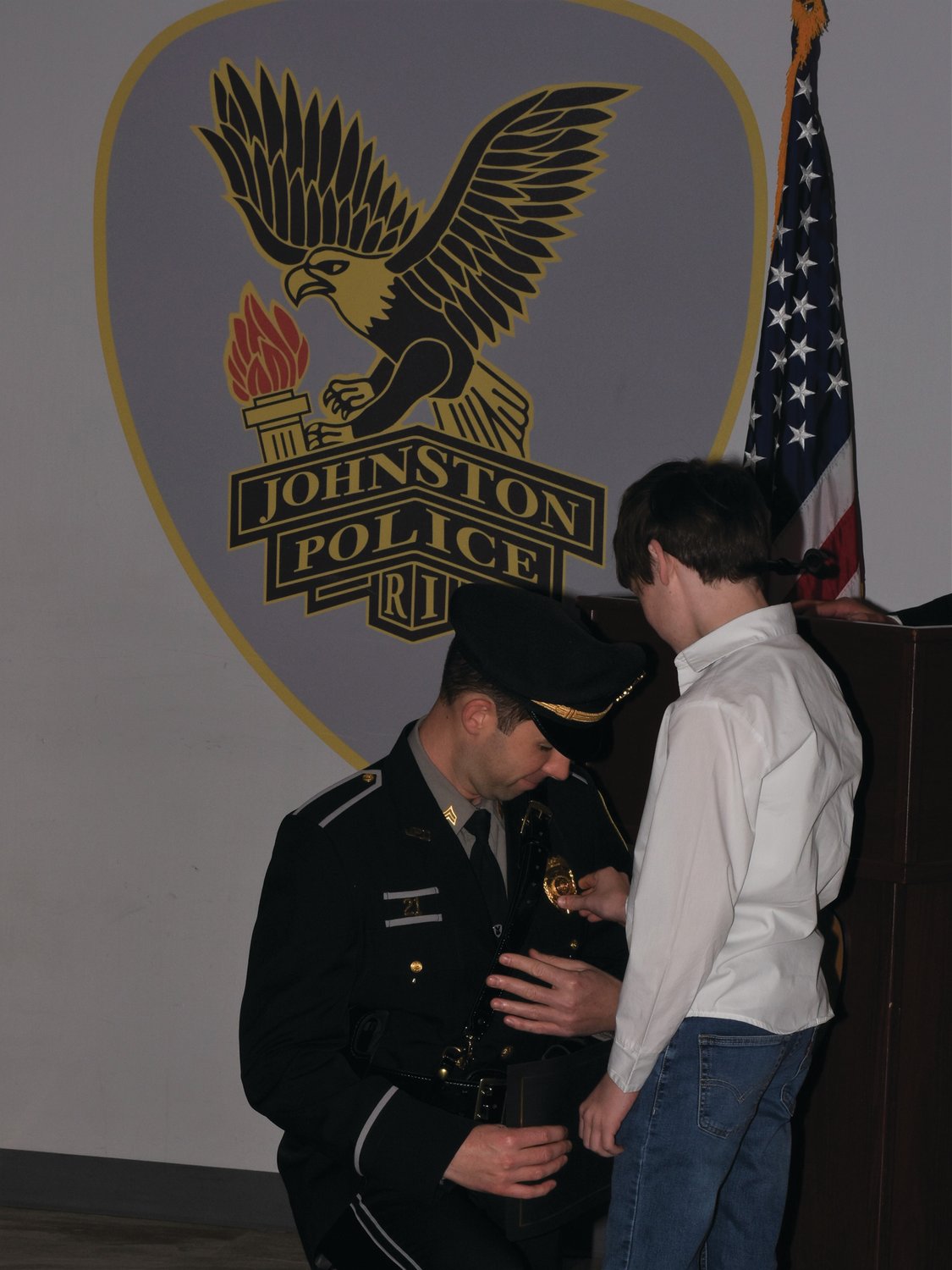 PROUDLY PINNED: Dillon Martufi pins a gold badge on his father, Michael Martufi, during his promotion to the rank of sergeant.